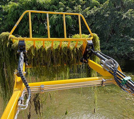 Yellow aquatic weed harvester lifting submerged vegetation
